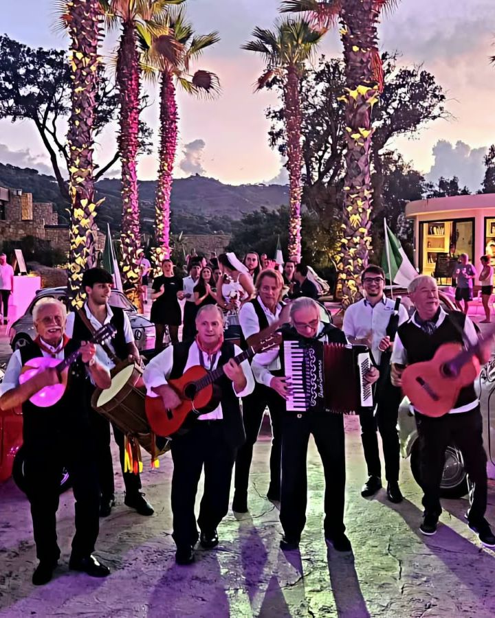 Il gruppo suona di sera tra le palme illuminate