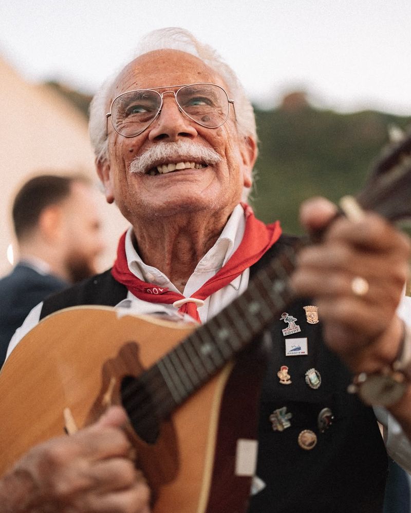 Uno dei cantori suona il mandolino, con il fazzoletto rosso al collo