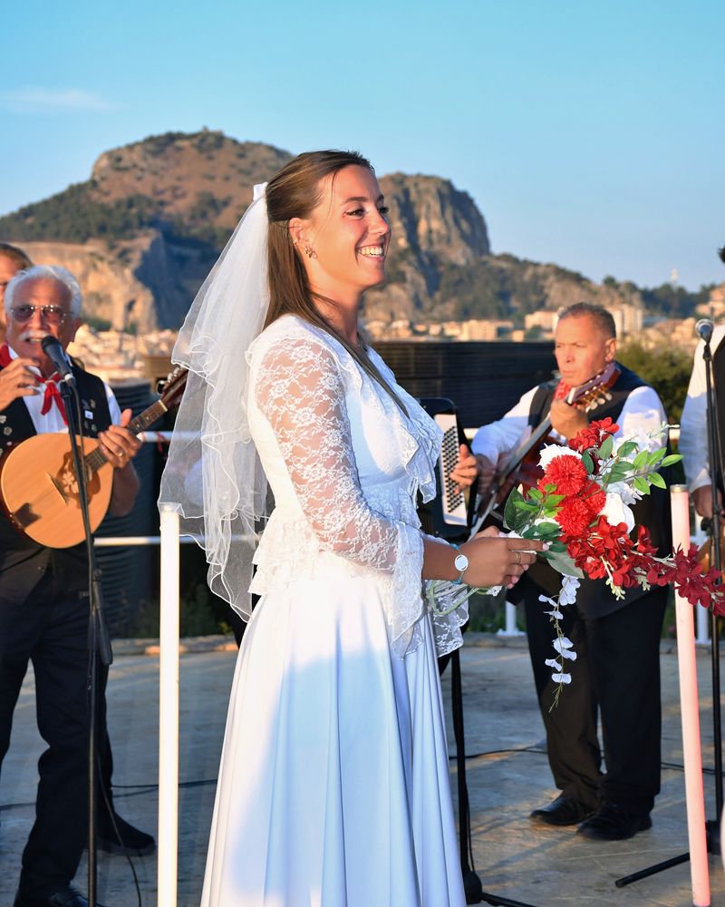 Una sposa sorride durante la serenata, con la Rocca sullo sfondo